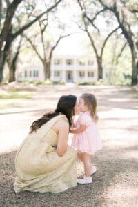 A mother kisses her daughter on the cheek in front of Rosedown Plantation near Baton Rouge